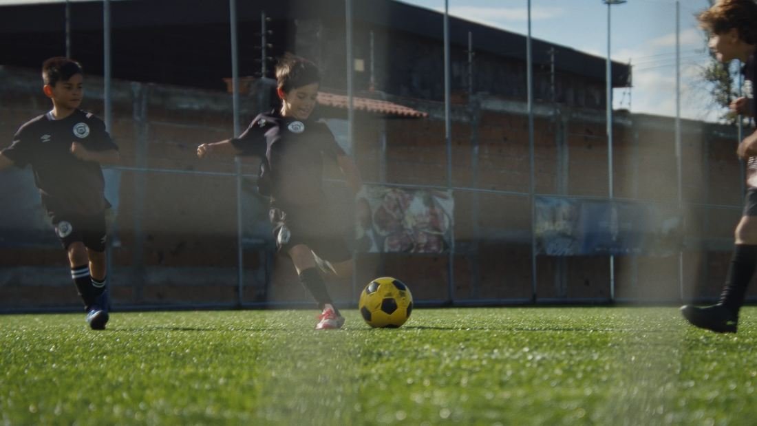 Jugadores disputan un balón en una cancha de fútbol